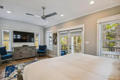 a bedroom with a large bed and a flat screen tv at Makin Memories by 30A Escapes in Rosemary Beach