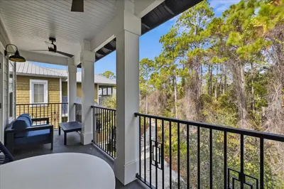 a balcony with a view of the woods at Makin Memories by 30A Escapes in Rosemary Beach