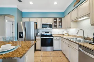 a kitchen with white cabinets and a stainless steel refrigerator at Seagrove Stillhouse by 30A Escapes in Seagrove Beach