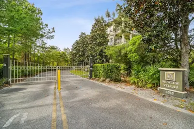 a road with a fence in front of a house at Seagrove Stillhouse by 30A Escapes in Seagrove Beach