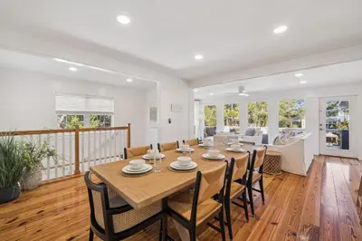 a dining room with a large wooden table and chairs at All Our Summers by 30A Escapes in Seagrove Beach