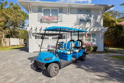 a golf cart parked in front of a house at All Our Summers by 30A Escapes in Seagrove Beach