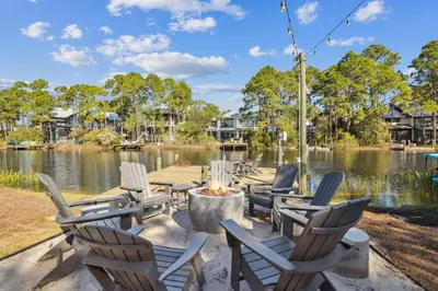 a group of chairs sitting next to a lake at All Our Summers by 30A Escapes in Seagrove Beach