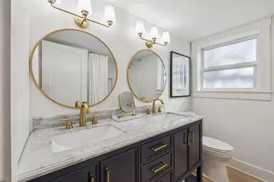 a bathroom with a sink and two mirrors at All Our Summers by 30A Escapes in Seagrove Beach