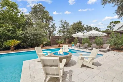 a patio with chairs and a fire pit next to a pool at NamaStay by 30A Escapes in Seacrest
