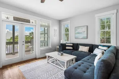 a living room with a blue couch and a table at Sunnyside #7 by 30A Escapes in Seacrest