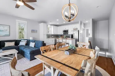 a living room with a table and a blue couch at Sunnyside #7 by 30A Escapes in Seacrest