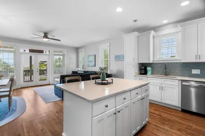 a kitchen with white cabinets and a living room at Sunnyside #7 by 30A Escapes in Seacrest