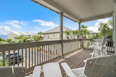 a balcony with white chairs and a view of the ocean at Sunnyside #7 by 30A Escapes in Seacrest