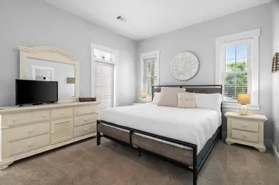 a bedroom with a bed and a flat screen tv at Sunnyside #7 by 30A Escapes in Seacrest