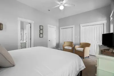 a white bedroom with a bed and a tv at Sunnyside #7 by 30A Escapes in Seacrest
