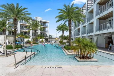 a swimming pool at a resort with palm trees at The Pointe Unit 111 by 30A Escapes in Rosemary Beach