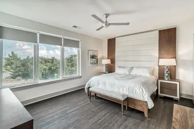 a bedroom with a bed and large windows at The Pointe Unit 121 by 30A Escapes in Rosemary Beach