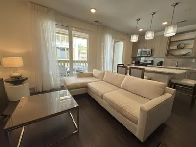 a living room with a white couch and a kitchen at The Pointe Unit 122 by 30A Escapes in Rosemary Beach