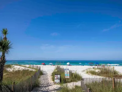 a path to a beach with a fence and the ocean at Horizon South 57-105 in Panama City Beach