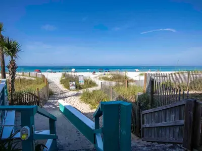 a beach with a blue bench and the ocean at Horizon South 57-105 in Panama City Beach