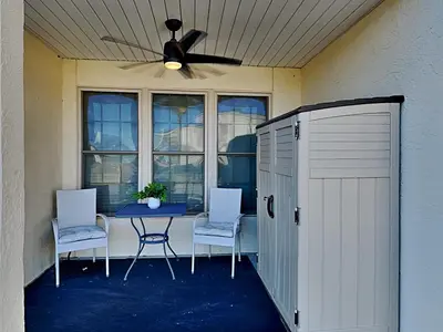 a patio with a table and two chairs and a ceiling fan at Horizon South 57-105 in Panama City Beach