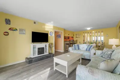 a living room with a couch and a fireplace at Moondrifter 207 in Panama City Beach
