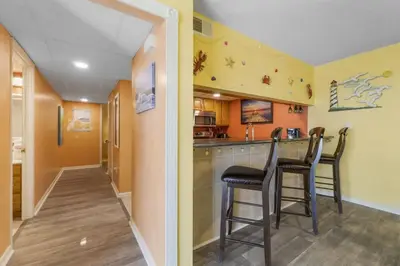 a kitchen with two chairs and a bar in a room at Moondrifter 207 in Panama City Beach