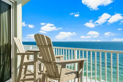 two chairs and a table on a balcony with the ocean at Stunning Gulf Front 3BD Condo! with Beach Chair Service for 4! presented by Dolce Vita Getaways PCB! in Panama City Beach