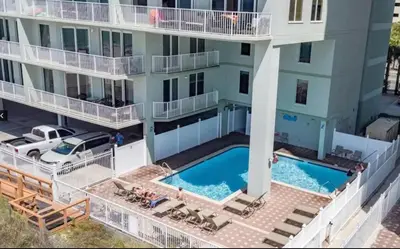 an aerial view of a building with a swimming pool at Stunning Gulf Front 3BD Condo! with Beach Chair Service for 4! presented by Dolce Vita Getaways PCB! in Panama City Beach