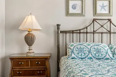 a bedroom with a bed with a lamp on a dresser at Stunning Gulf Front 3BD Condo! with Beach Chair Service for 4! presented by Dolce Vita Getaways PCB! in Panama City Beach