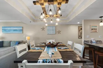 a dining room with a table and a couch at Watercrest 1704 - Serenity Shores in Panama City Beach