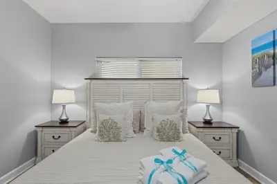 a bedroom with a bed with two lamps and towels at Shores of Panama 1408 - Seaside Getaway in Panama City Beach