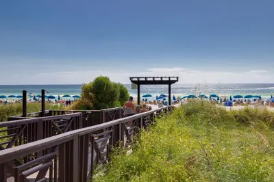 a group of people walking down a boardwalk to the beach at Shores of Panama 1410 - Seaside Retreat in Panama City Beach