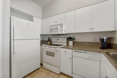 a white kitchen with white appliances and white cabinets at Shores of Panama 1410 - Seaside Retreat in Panama City Beach