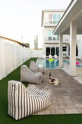 a patio with two couches and a swimming pool at The Taj Of The Gulf! Luxury Beach Mansion! Sleeps 37, private pool & hot tub, putting golf in Panama City Beach