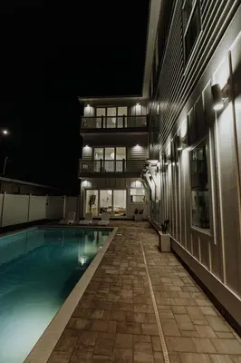 a building with a swimming pool at night at The Taj Of The Gulf! Luxury Beach Mansion! Sleeps 37, private pool & hot tub, putting golf in Panama City Beach