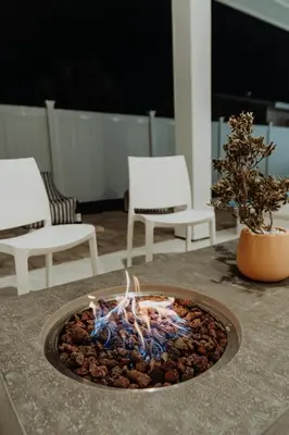 a fire pit sitting on top of a table with chairs at The Taj Of The Gulf! Luxury Beach Mansion! Sleeps 37, private pool & hot tub, putting golf in Panama City Beach