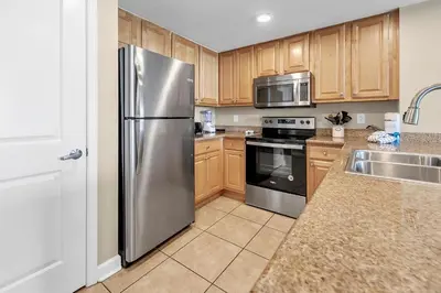 a kitchen with wooden cabinets and a stainless steel refrigerator at Marisol 204 by Emerald Coast Retreats in Panama City Beach