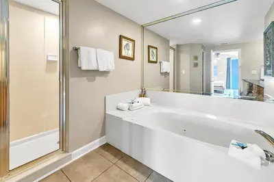 a bathroom with a tub and a large mirror at Marisol 204 by Emerald Coast Retreats in Panama City Beach