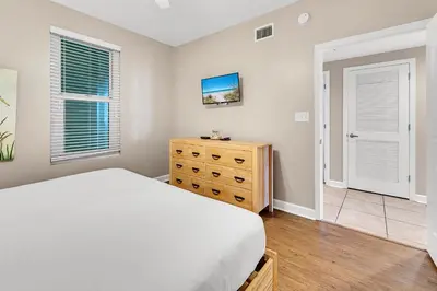 a bedroom with a bed and a dresser and windows at Marisol 204 by Emerald Coast Retreats in Panama City Beach