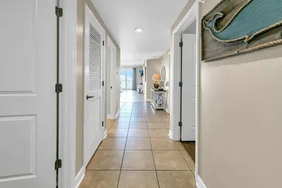 a hallway with white doors and a tile floor at Marisol 204 by Emerald Coast Retreats in Panama City Beach
