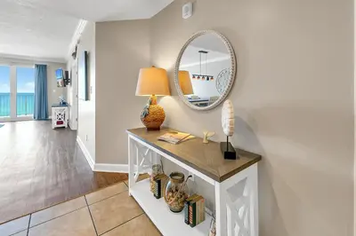 a white room with a table with a mirror at Marisol 204 by Emerald Coast Retreats in Panama City Beach