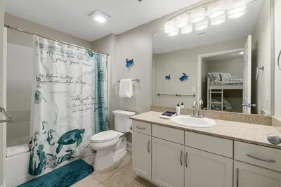 a bathroom with a toilet sink and a shower curtain at Lakeview Luxury at Laketown Wharf #235 by Nautical Properties in Panama City Beach