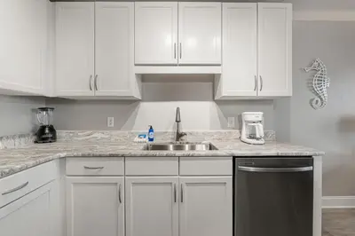 a kitchen with white cabinets and a sink at Lakeview Luxury at Laketown Wharf #235 by Nautical Properties in Panama City Beach