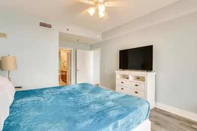 a bedroom with a bed and a flat screen tv at Panama City Beach Condo - Walk to the Ocean! in Panama City Beach