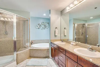 a bathroom with two sinks and a shower and a tub at Panama City Beach Condo - Walk to the Ocean! in Panama City Beach