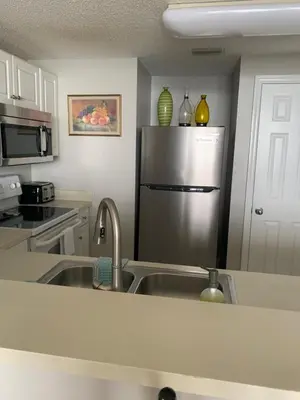 a kitchen with a sink and a stainless steel refrigerator at Majestic Beach Towers 905 in Panama City Beach