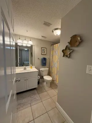 a bathroom with a sink toilet and a mirror at Majestic Beach Towers 905 in Panama City Beach