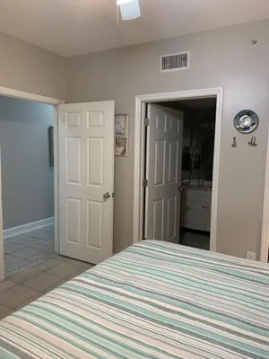 a bedroom with a large bed and a bathroom at Majestic Beach Towers 905 in Panama City Beach