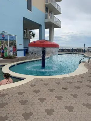 a pool with a fountain in front of a building at Majestic Beach Towers 905 in Panama City Beach