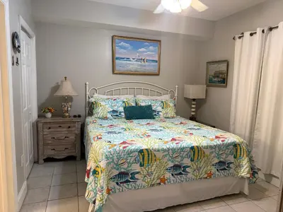 a bedroom with a bed with a colorful comforter at Majestic Beach Towers 905 in Panama City Beach