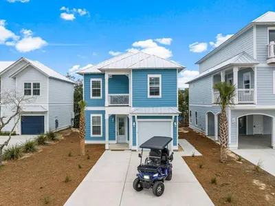 a stroller is parked in front of a blue house at Special ! Free Golf Cart ! Spring Paradise! in Panama City Beach