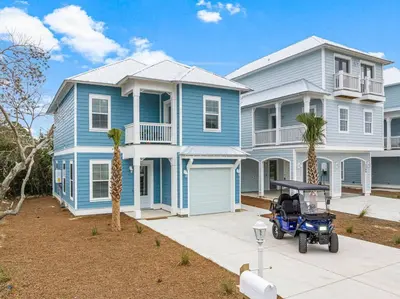 a blue house with a golf cart in front of it at Special ! Free Golf Cart ! Spring Paradise! in Panama City Beach