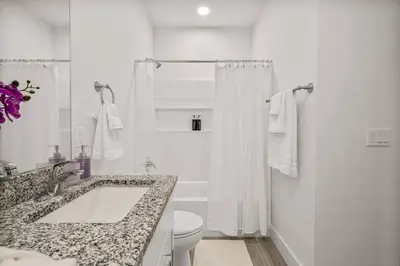 a white bathroom with a tub and a toilet at Special ! Free Golf Cart ! Spring Paradise! in Panama City Beach